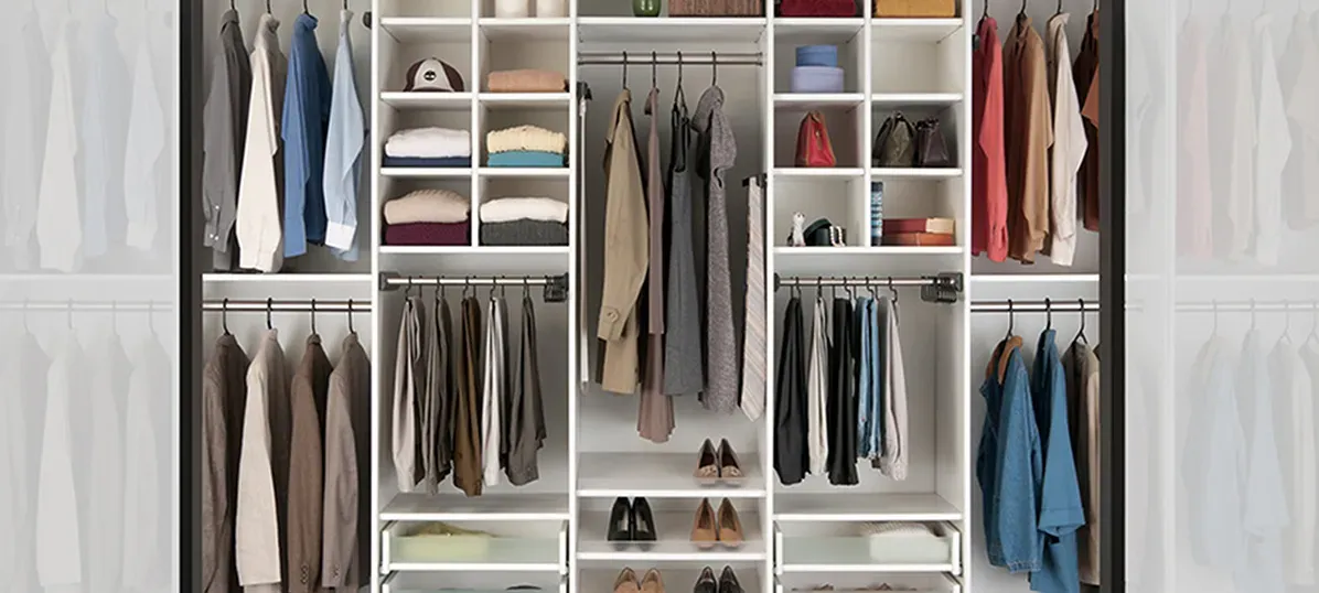 Closet interior with hanging white and blue clothes and shelves with towels