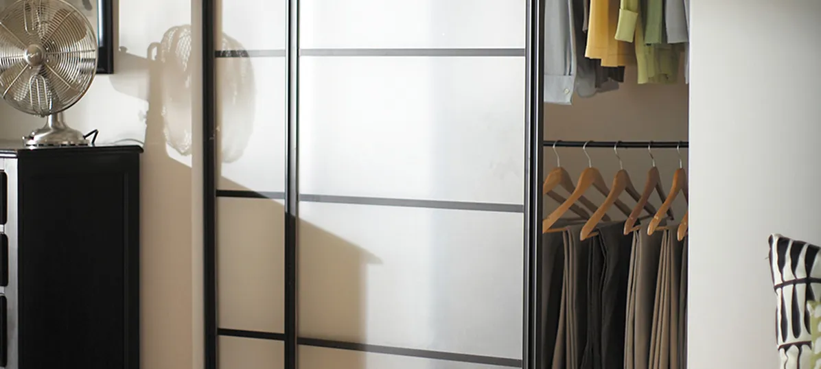 Interior of a cabinet with drawers and a black pot with green plant on top