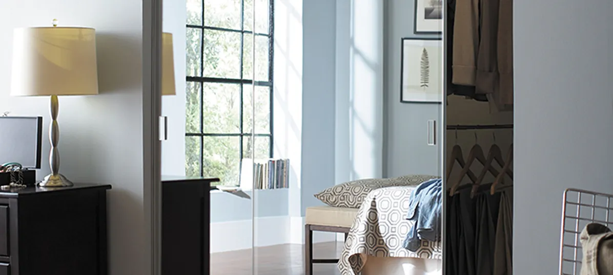 Closet interior with hanging white and blue clothes and shelves with towels